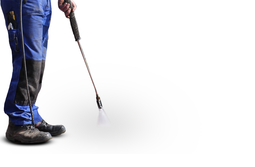 Pressure washer in use by a worker wearing safety gear, highlighting professional exterior cleaning services for driveways and patios.