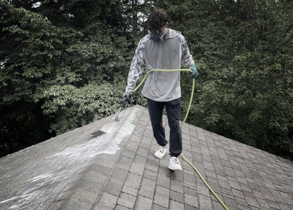 Frater Exterior Services doing a roof treatment to prevent moss buildup on a Westcoast house on Vancouver Island