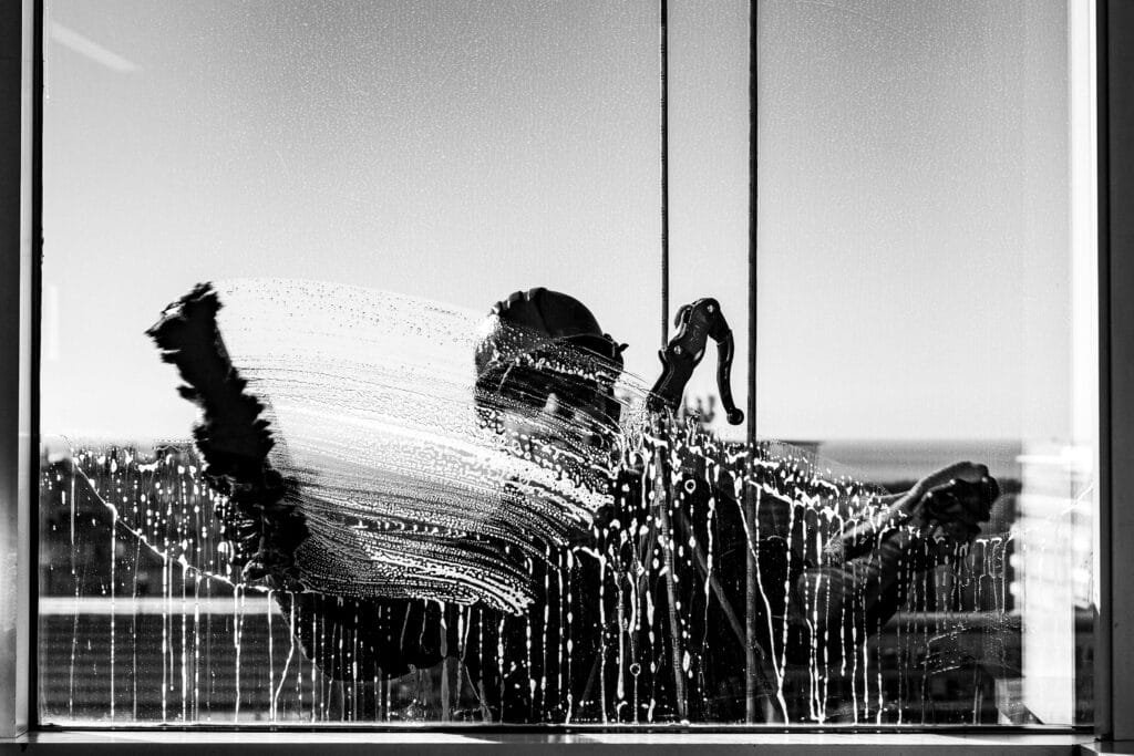 Artistic black‑and‑white swirl showing Victoria BC window cleaner scrubbing exterior glass