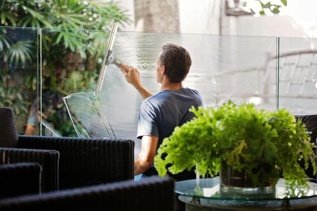 Victoria BC technician squeegeeing patio glass panels for a streak‑free outdoor view