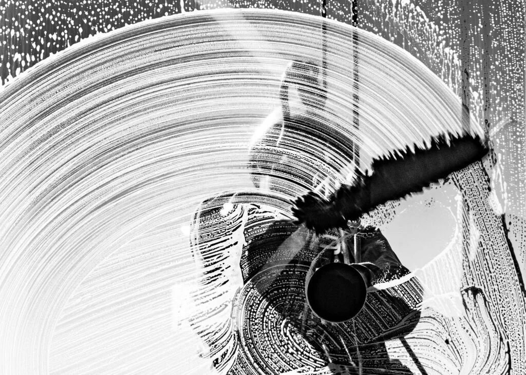 Silhouette of a Victoria BC window cleaner sweeping squeegee in circular motion